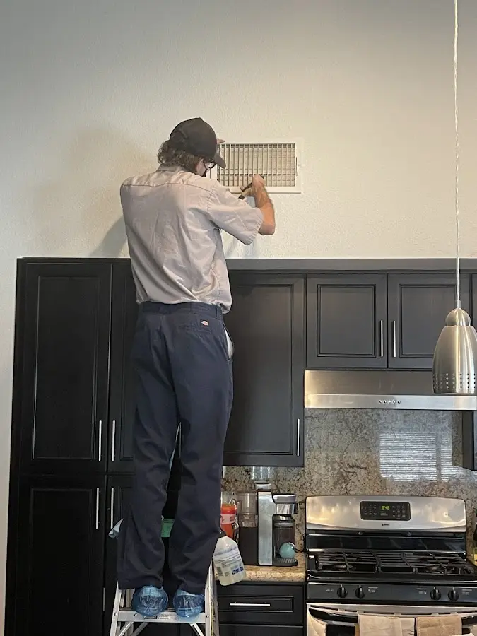 Technician inspecting an air vent during HVAC service in Elizabethtown